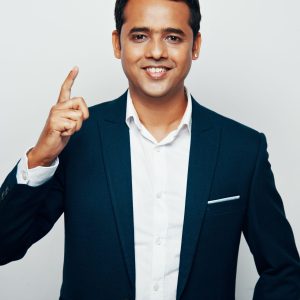 medium-shot-handsome-indian-man-formalwear-posing-against-white-wall-with-his-pointer-up